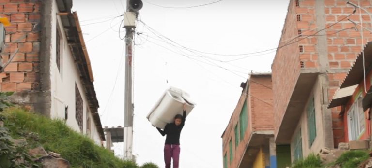 Abriéndose camino, con una lavadora a la espalda