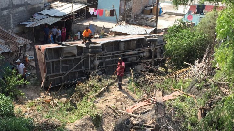 Camión de transporte de personal embiste coche y terminan al fondo de arroyo