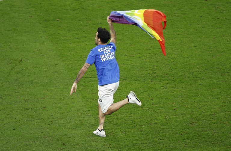 Un aficionado salta al césped con una bandera arcoíris durante el partido entre Portugal y Uruguay