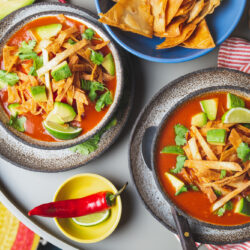 Mexican style table with spicy aztec soup with tortilla. Copy space