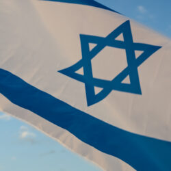 Israel national flag waving on sky background