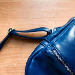 Close up of blue leather women backpack, rucksack detail on wood
