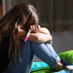 Sad pregnant teen after pregnancy test